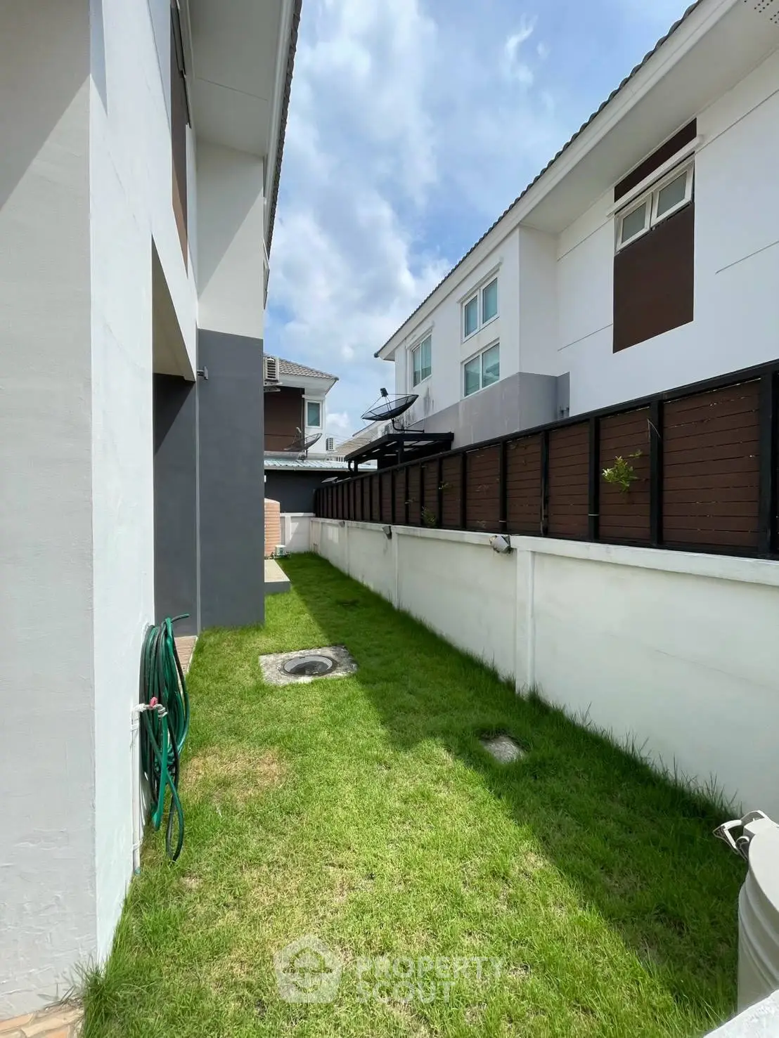 Charming townhouse exterior with lush green lawn and modern design, perfect for family living.