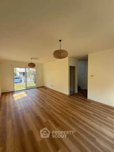 Spacious living room with wooden flooring and natural light
