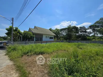 Charming countryside house with lush green surroundings and clear blue sky, perfect for serene living.