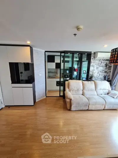 Spacious modern living room with sleek wooden flooring and cozy beige sofa