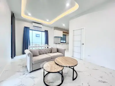 Modern living room with elegant sofa and stylish dining area in open layout apartment.