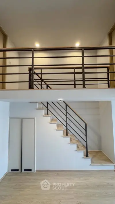 Modern loft-style interior with sleek staircase and open mezzanine