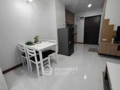 Modern apartment interior with dining area and kitchen, featuring sleek furniture and neutral tones.