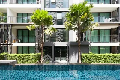 Modern apartment building with pool and lush greenery