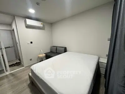 Modern bedroom with minimalist design, featuring a cozy bed, sleek sofa, and stylish decor.