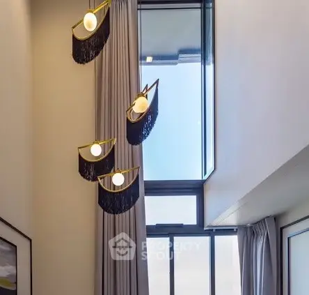 Elegant modern living room with high ceiling and stylish pendant lights