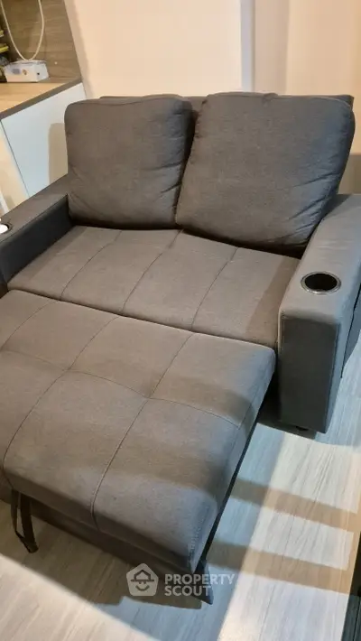 Modern gray sofa bed with cup holder in stylish living room setting