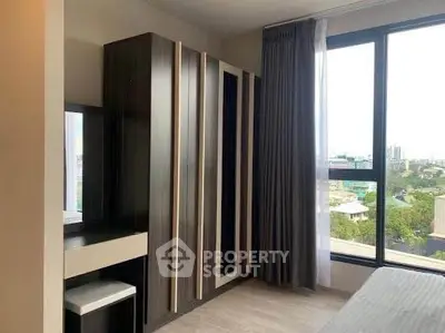 Modern bedroom with large window and stylish wardrobe offering city views.