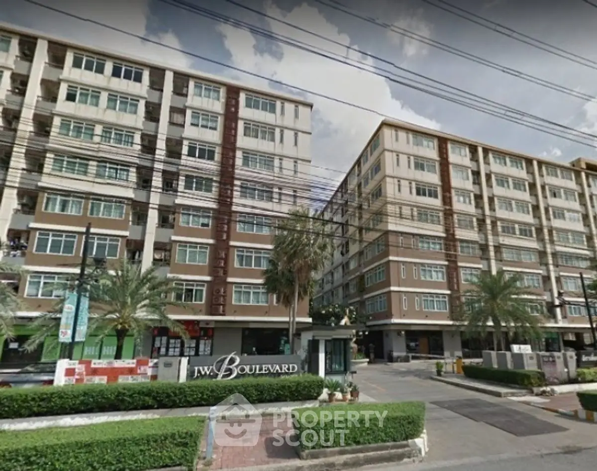 Modern apartment complex with palm trees and spacious entrance