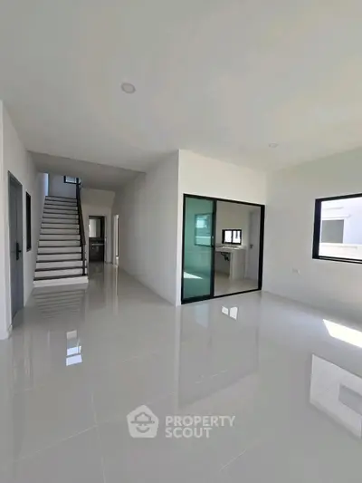 Spacious modern interior with glossy floors and staircase, ideal for contemporary living.
