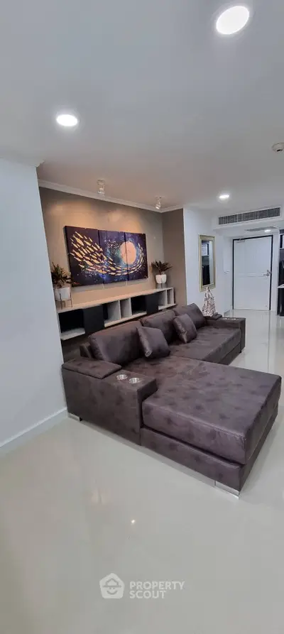 Modern living room with stylish gray sofa and contemporary wall art