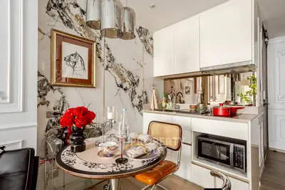 Chic modern kitchen with marble accents and stylish dining area in luxury apartment.