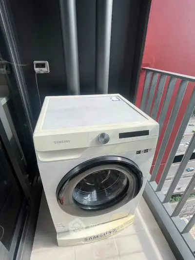 Modern washing machine on a balcony with city view, perfect for urban living convenience.
