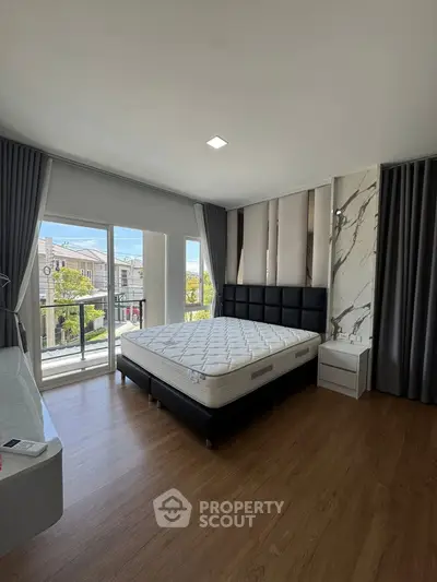 Spacious bedroom with modern decor and balcony view