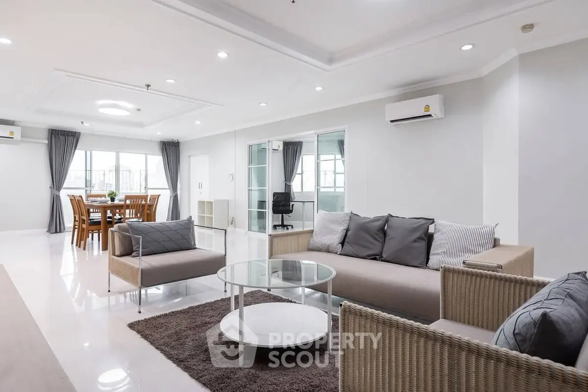 Spacious modern living room with elegant dining area and stylish furniture in open layout.