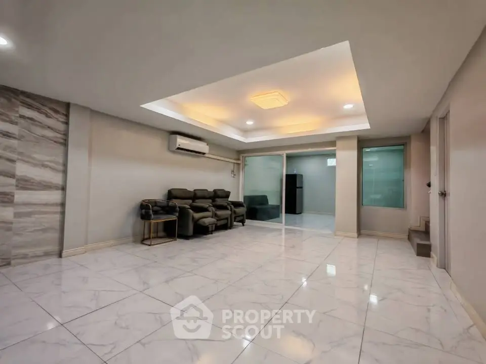 Spacious modern living room with elegant marble flooring and cozy seating area.