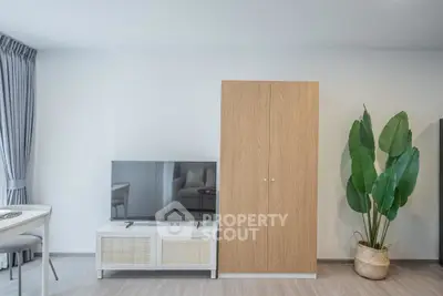 Modern living room with sleek TV stand and wardrobe, featuring stylish decor and natural light.