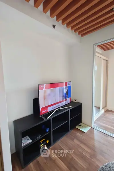 Modern living room with wooden ceiling accents and sleek TV stand