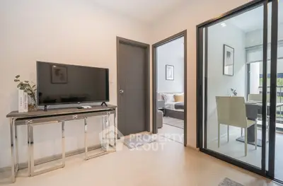 Modern living room with sleek TV stand and sliding glass doors leading to a cozy dining area.