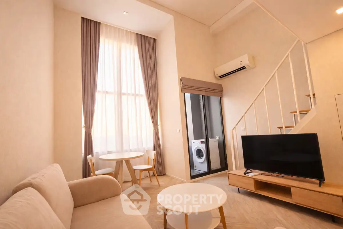 Modern living room with high ceiling and washing machine in cozy apartment