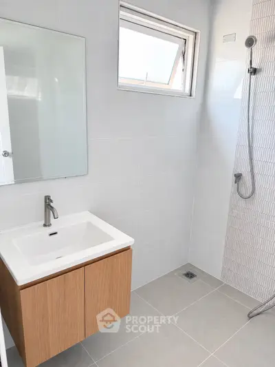 Modern bathroom with sleek vanity and walk-in shower in contemporary home.
