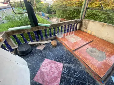 Charming balcony with colorful tiles and lush greenery view, perfect for relaxation.