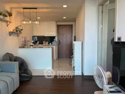 Modern living room with cozy seating and stylish kitchen in open layout apartment.