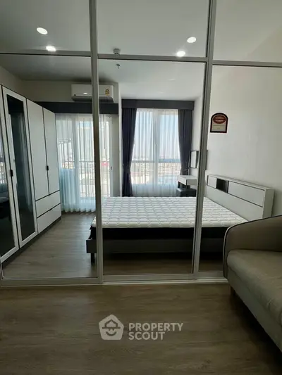 Modern bedroom with large windows and sleek furniture in a stylish apartment.