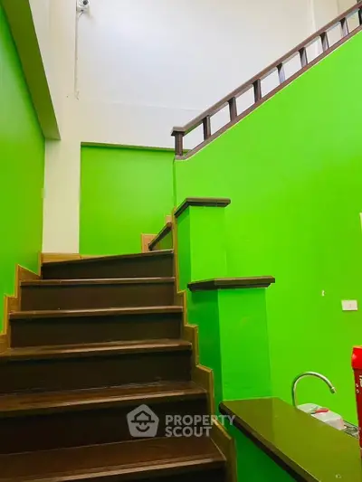 Vibrant green staircase with modern wooden railing in a stylish home interior