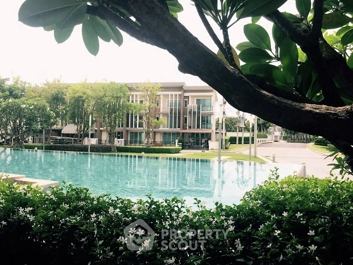 Luxurious residential building with serene pool and lush greenery, perfect for tranquil living.