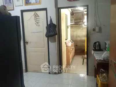 Cozy interior with kitchen and hallway view, featuring essential appliances and tiled flooring.