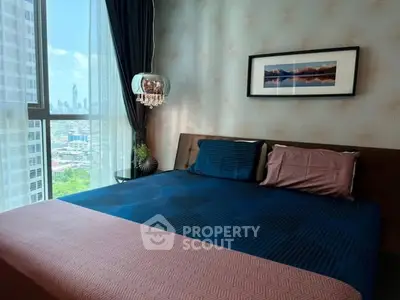 Modern bedroom with city view, stylish decor, and large window for natural light.