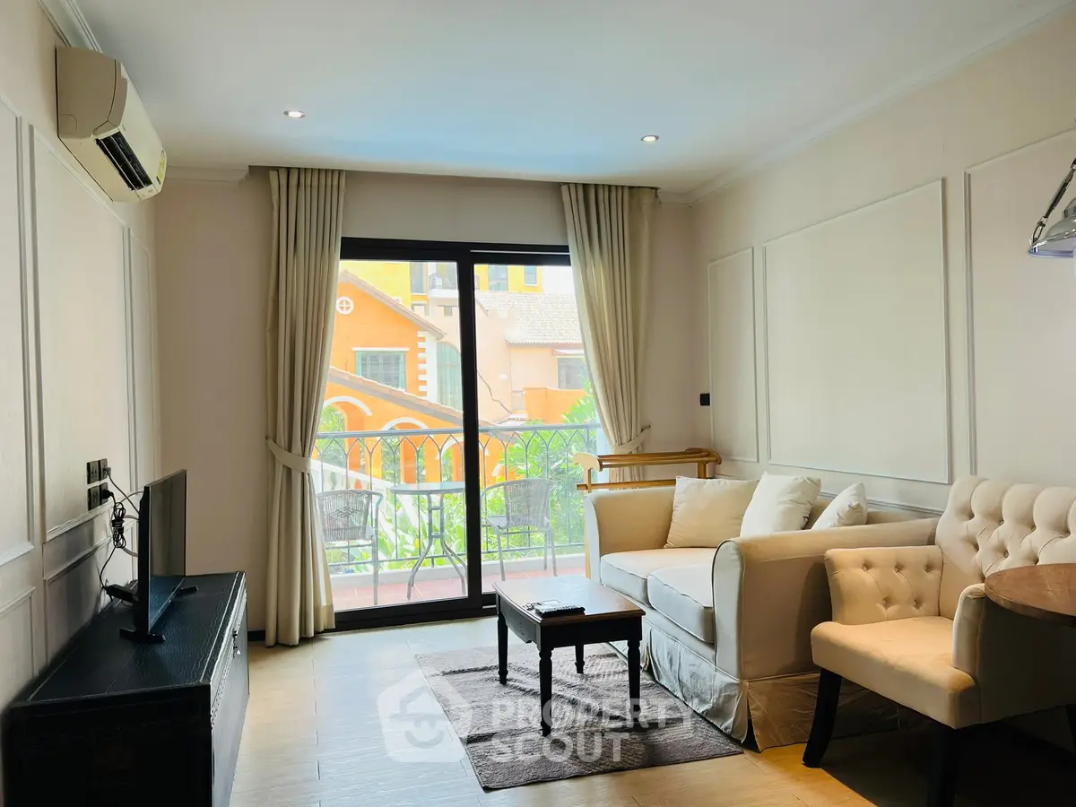 Charming living room with elegant decor and balcony view, perfect for relaxation.