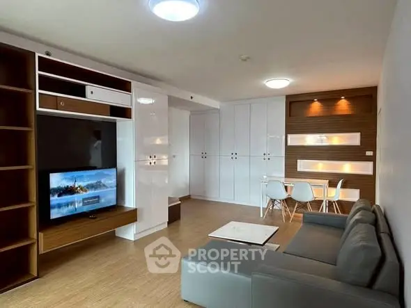 Modern living room with sleek furniture and built-in storage solutions.