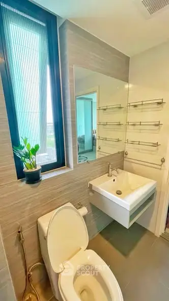 Modern bathroom with sleek fixtures and large window offering natural light.