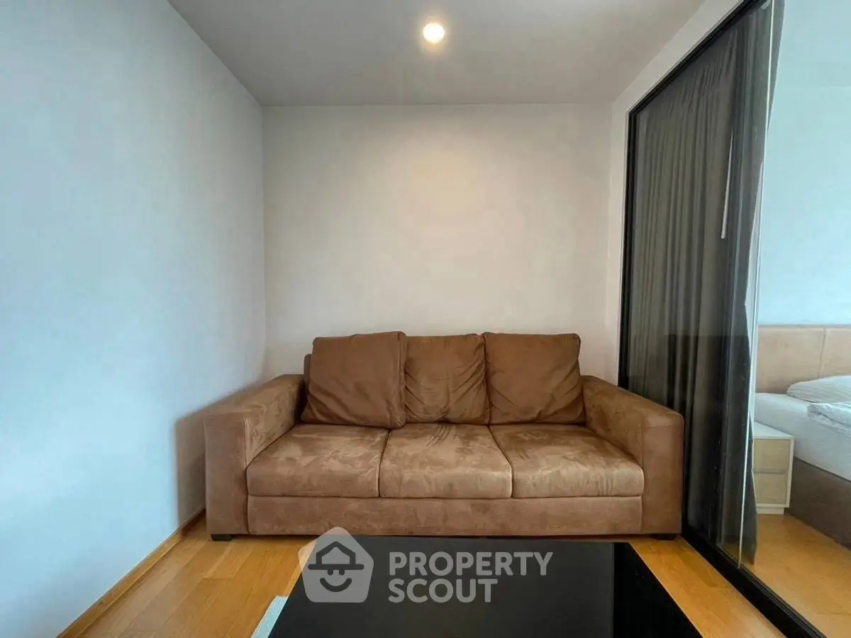Cozy living room with brown sofa and modern glass partition