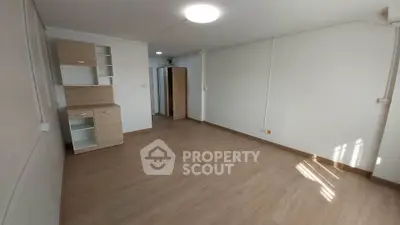 Spacious unfurnished room with wooden flooring and built-in storage, ideal for customization.