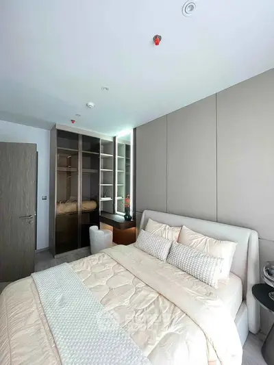Luxurious bedroom with modern design, featuring plush bedding and sleek built-in wardrobe.