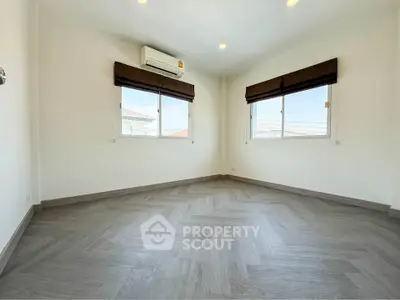 Spacious bedroom with modern flooring and ample natural light from large windows.