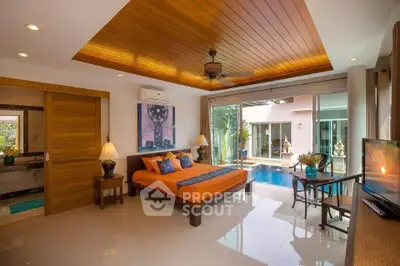 Luxurious bedroom with pool view, wooden ceiling, and modern decor in a tropical villa.