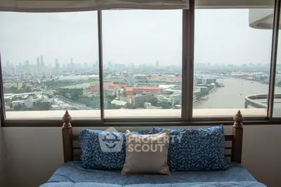 Stunning cityscape view from a cozy bedroom with large windows and comfortable bedding.