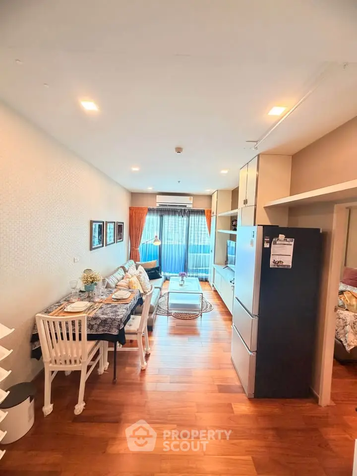 Charming living room with elegant dining area and cozy seating, featuring wooden flooring and ample natural light.