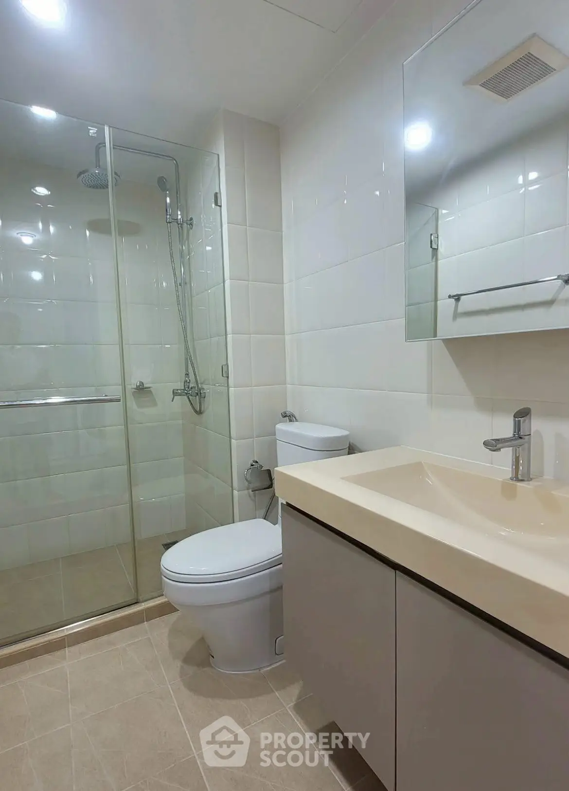Modern bathroom with glass shower, sleek vanity, and neutral tiles