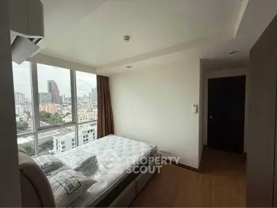 Modern bedroom with city view and large windows in high-rise apartment