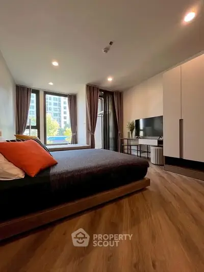 Modern bedroom with large window and stylish decor in urban apartment