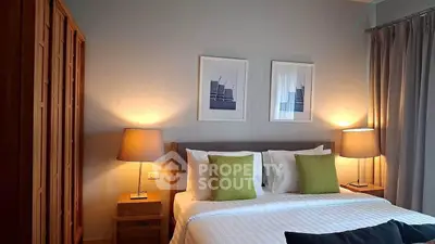Cozy bedroom with modern decor, featuring a comfortable bed, stylish lamps, and elegant artwork.