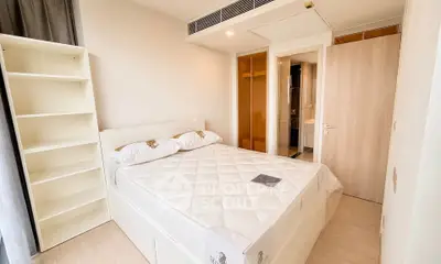 Modern bedroom with cozy bed and built-in wardrobe in a stylish apartment.