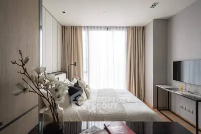 Modern bedroom with elegant decor and natural light, featuring a stylish bed and wall-mounted TV.