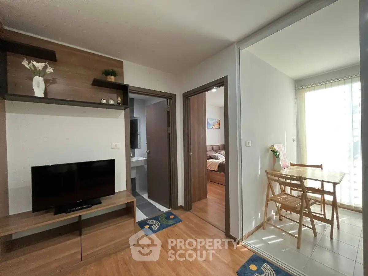Modern apartment interior with cozy living area and dining space, featuring wooden flooring and stylish decor.