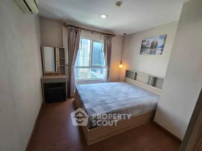 Cozy bedroom with city view, featuring a large window, wooden flooring, and modern furnishings.